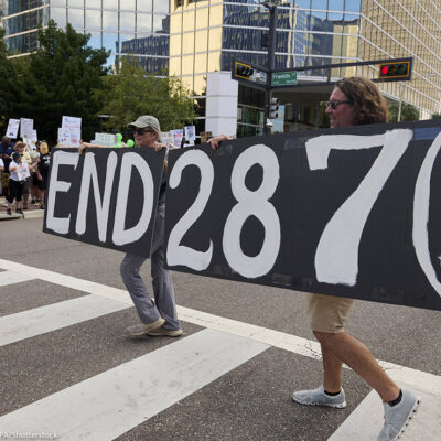 People in Florida carry a sign calling for an end to 287(g).