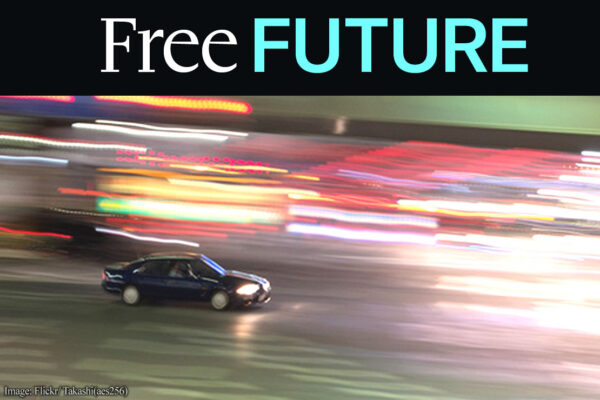 A sole car driving at night amid bright blurry lights
