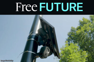A license plate reader against sky and trees