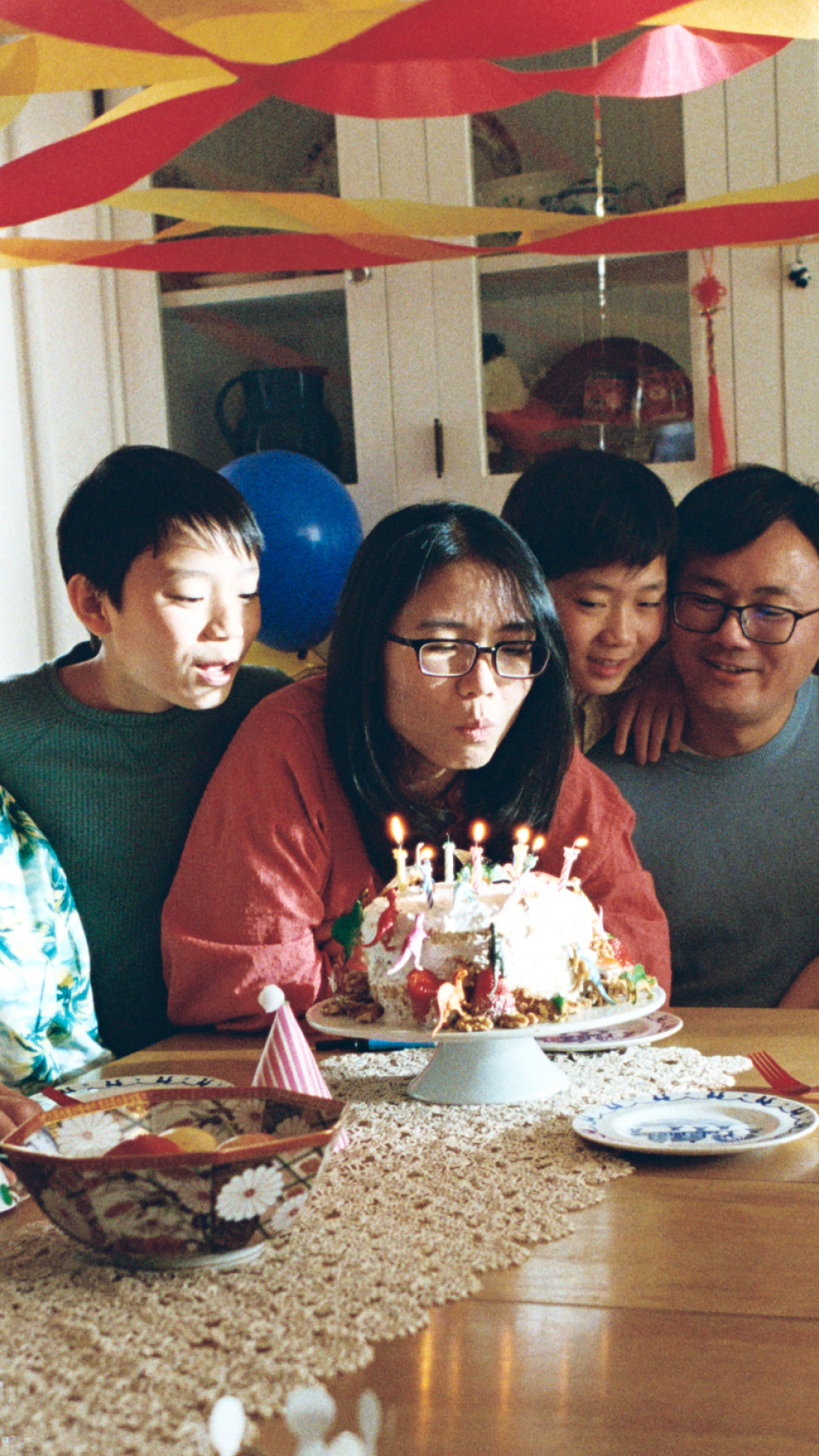 A young woman blows out a birthday cake.