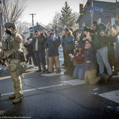 A photos of demonstrators in Minneapolis filming federal agents.
