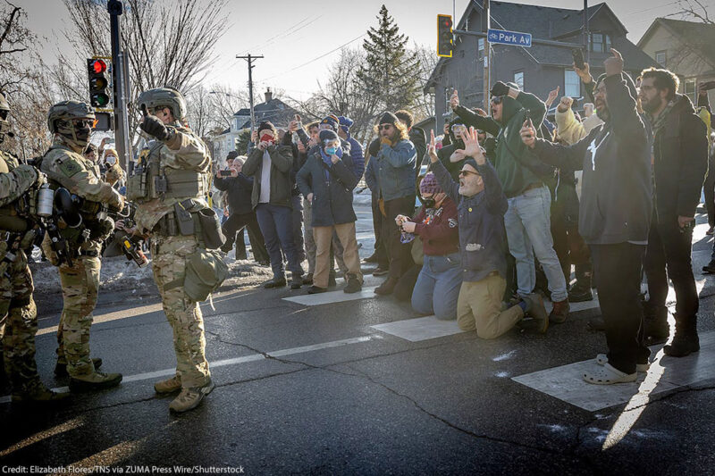 A photos of demonstrators in Minneapolis filming federal agents.