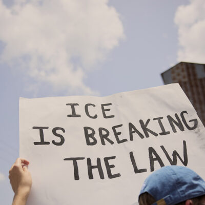 A demonstrator at the Journey to Justice rally in Basile, Louisiana on June 30, 2025 holding a sign that says, "ICE is Breaking The Law."