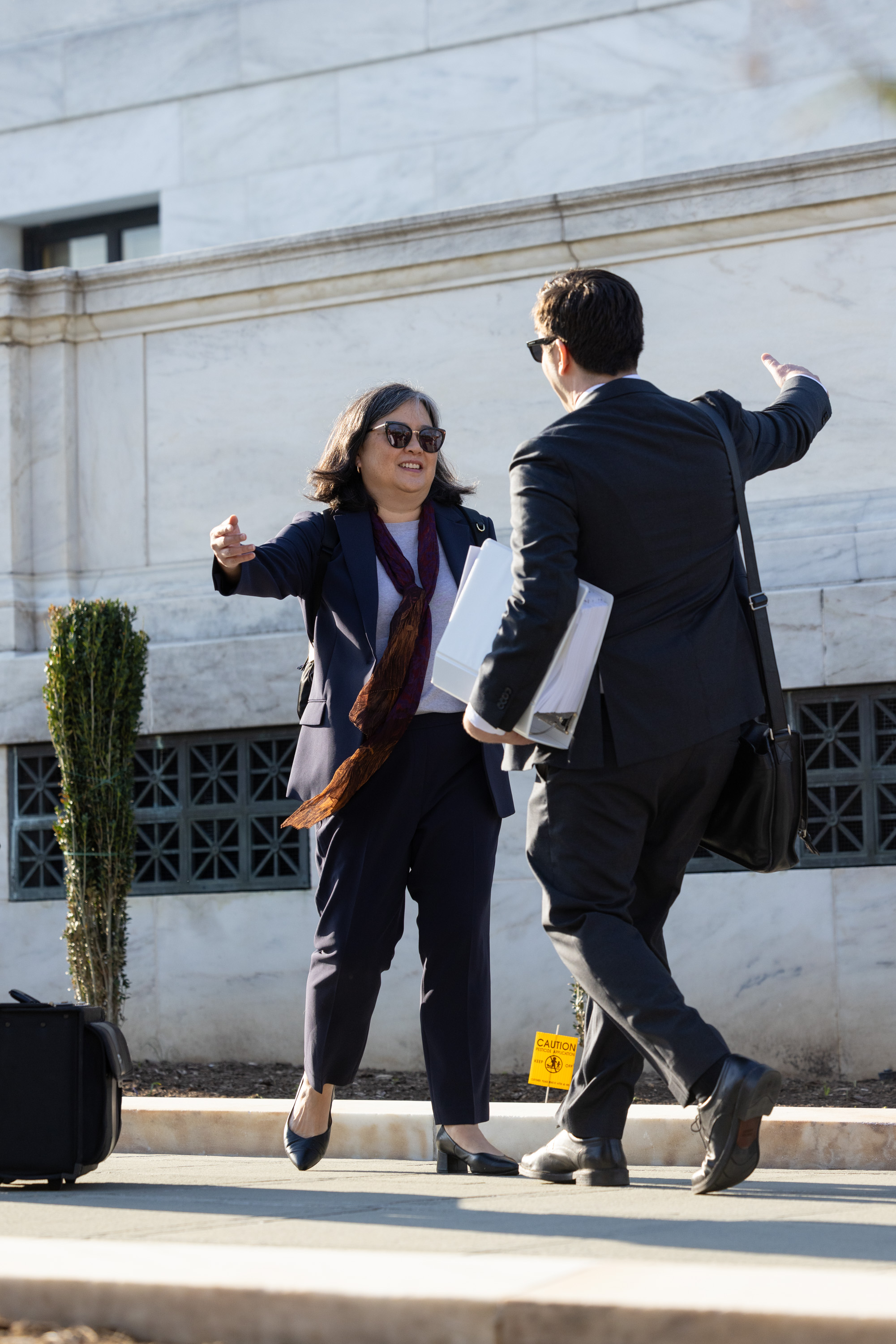Cecillia Wang hugs a colleague outside the Supreme Court.