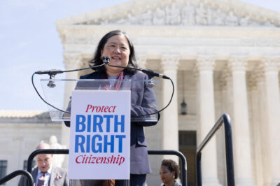 ACLU National Legal Director Cecillia Wang speaks outside the Supreme Court. A sign on the podium says Protect Birthright Citizenship.