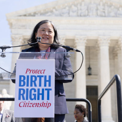 ACLU National Legal Director Cecillia Wang speaks outside the Supreme Court. A sign on the podium says Protect Birthright Citizenship.