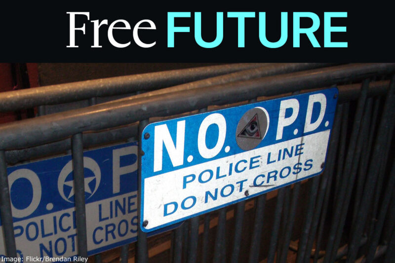 A sign on a metal rack reading "N.O.P.D. / police line / do not cross"