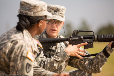 A woman Drill Sergeant candidate given instruction by a women Drill Sergeant instructor.