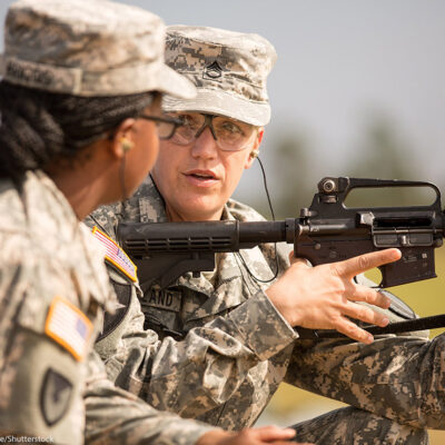 A woman Drill Sergeant candidate given instruction by a women Drill Sergeant instructor.
