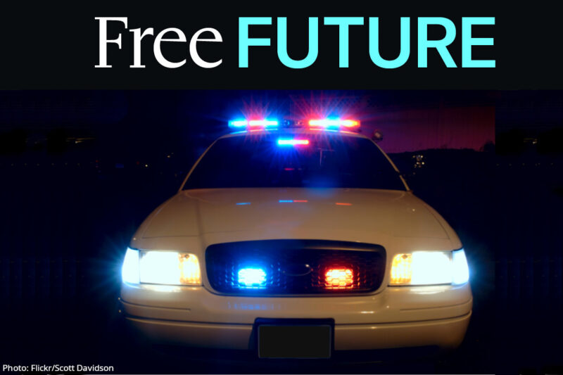 A frontal view of a police car with its lights on at night