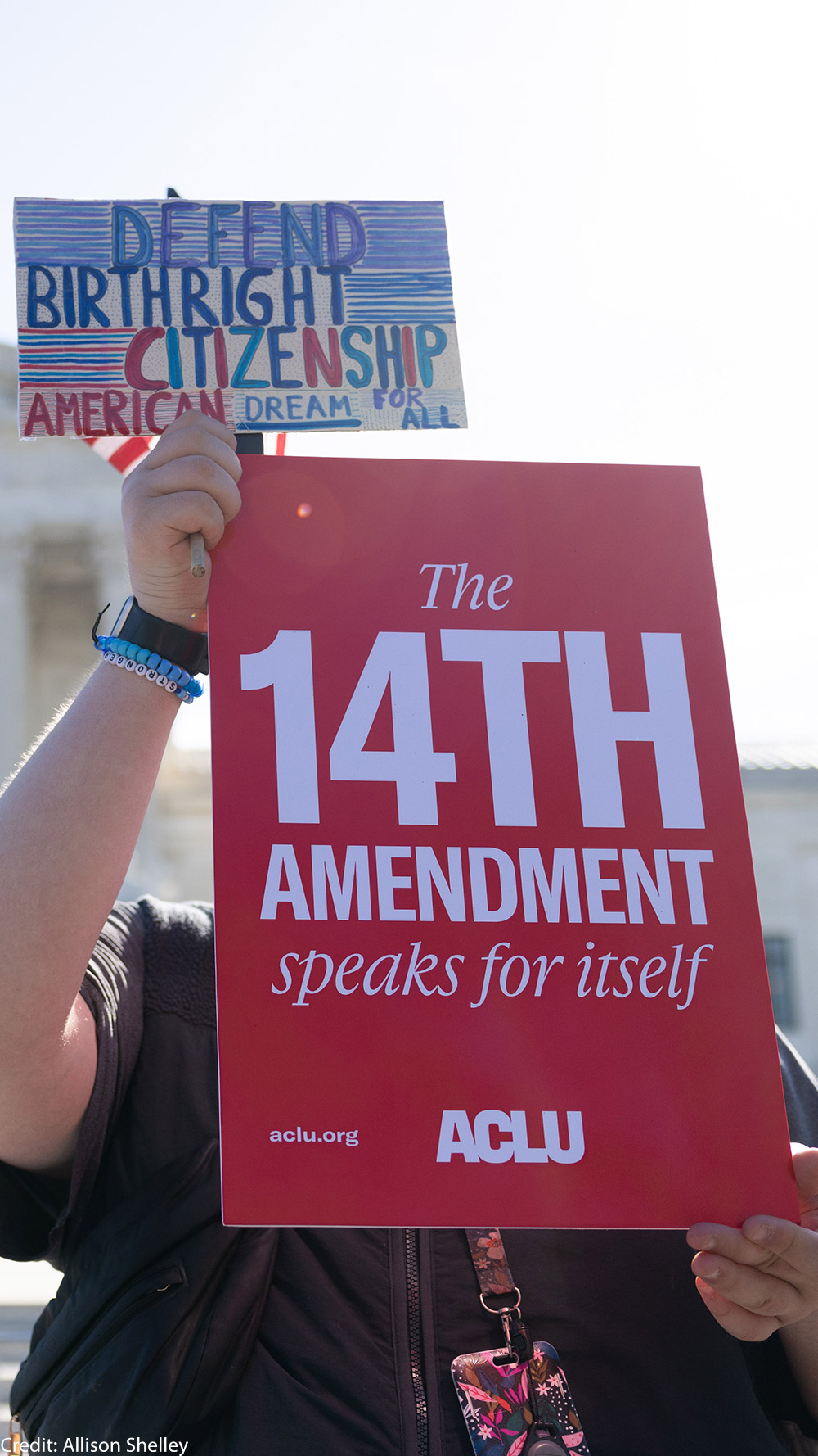 A demonstrator holding signs advocating for the 14th Amendment at the U.S. Supreme Court in Washington, D.C. for the birthright citizenship case Trump v. Barbara.