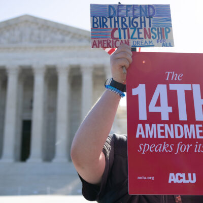 A demonstrator holding signs advocating for the 14th Amendment at the U.S. Supreme Court in Washington, D.C. for the birthright citizenship case Trump v. Barbara