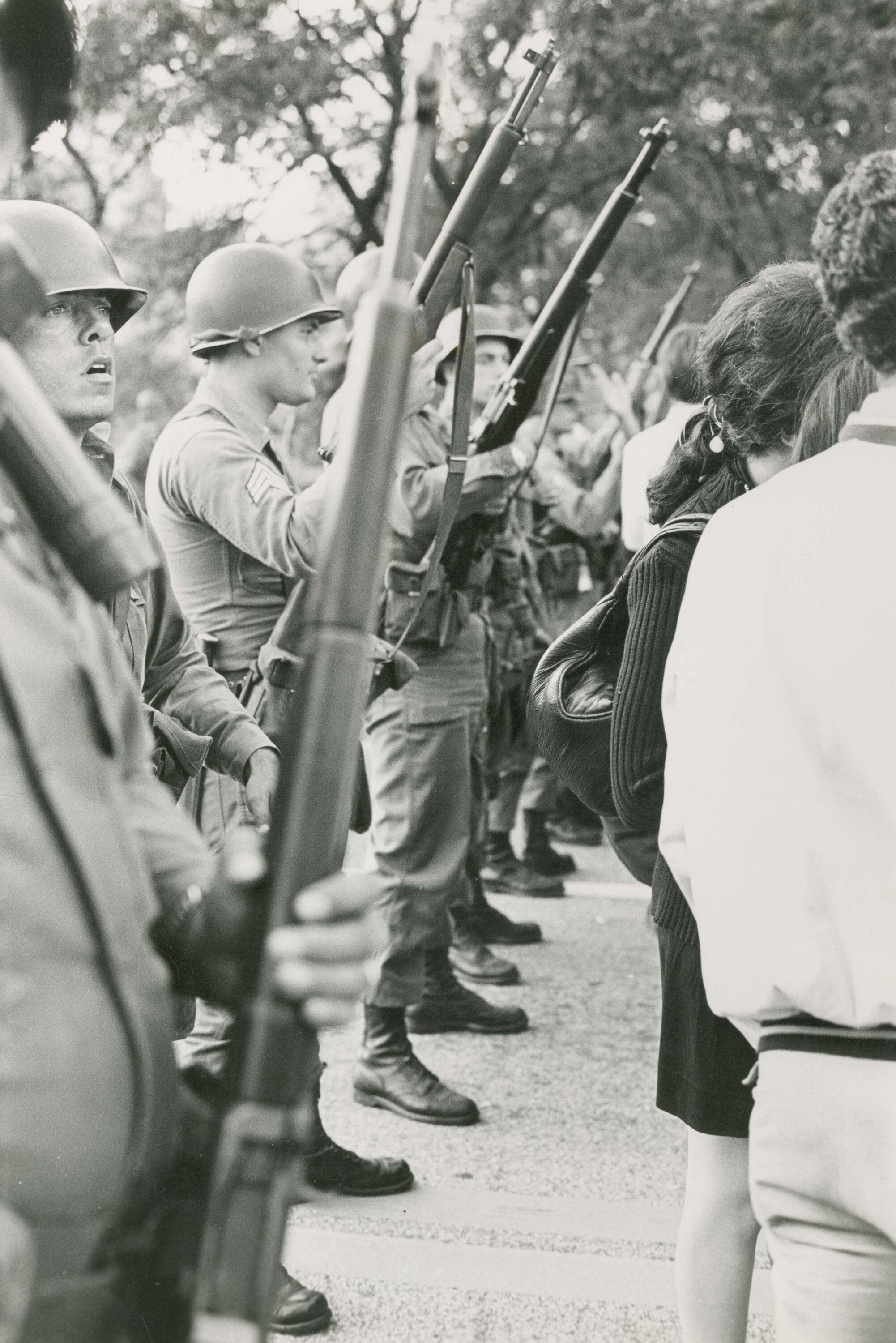 National guardsman stand in a row while civilians pass by them