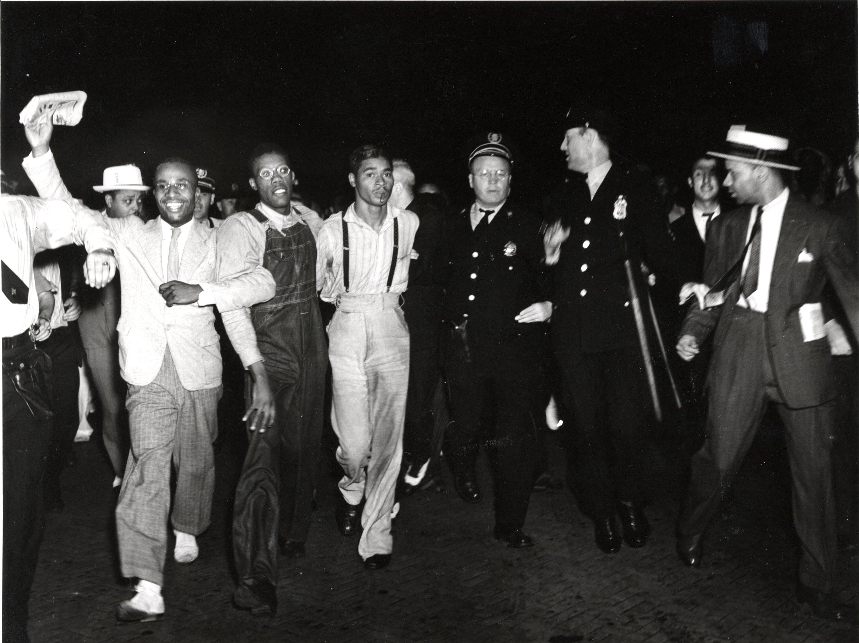 Black and white photo of the Scottsboro Case defendants celebrate in a New York City crowd