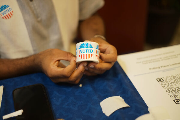 Person holds a ream of "I Voted" stickers