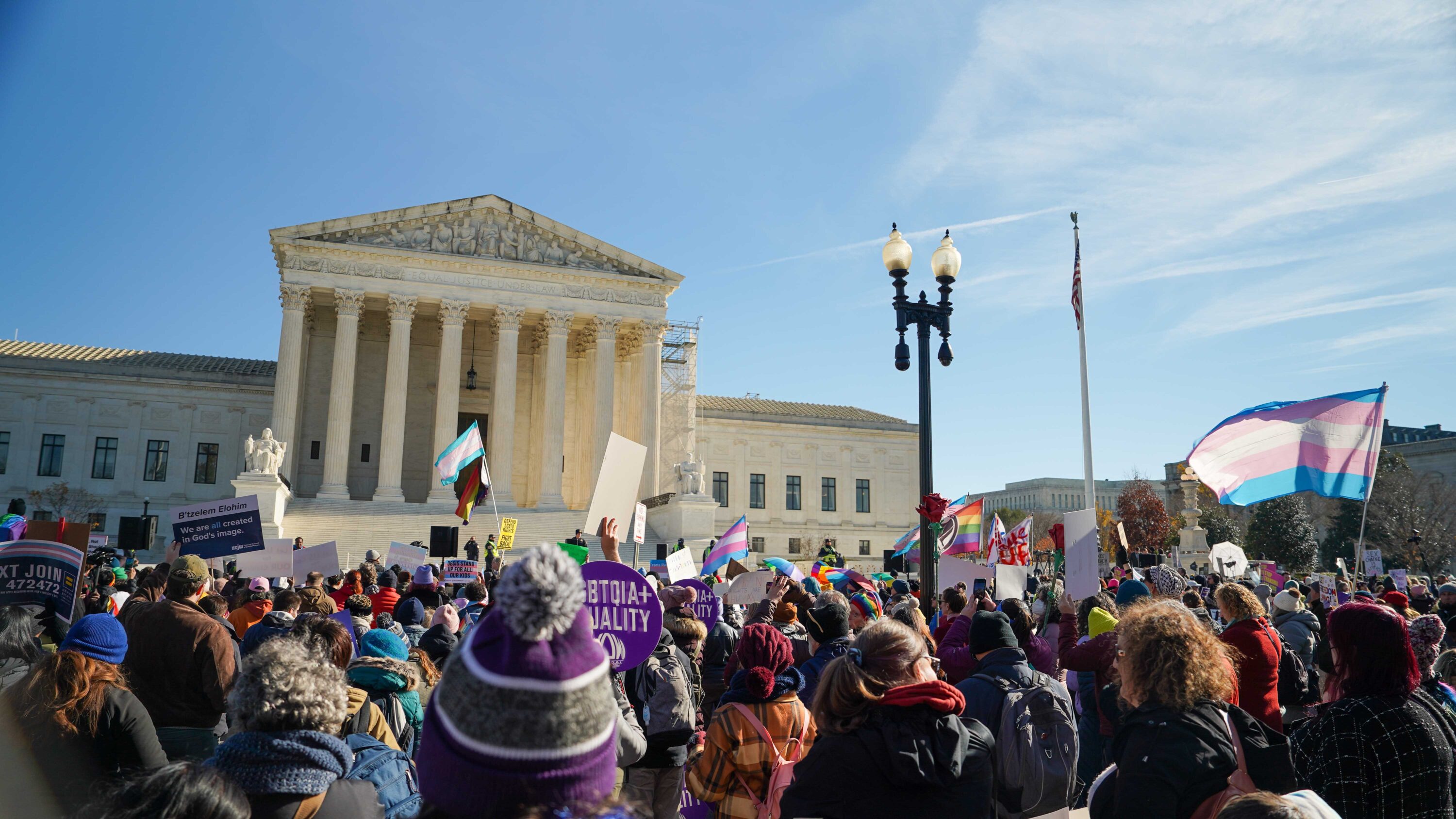 People rally outside of the Supreme Court during arguments in the case US v Skrmetti