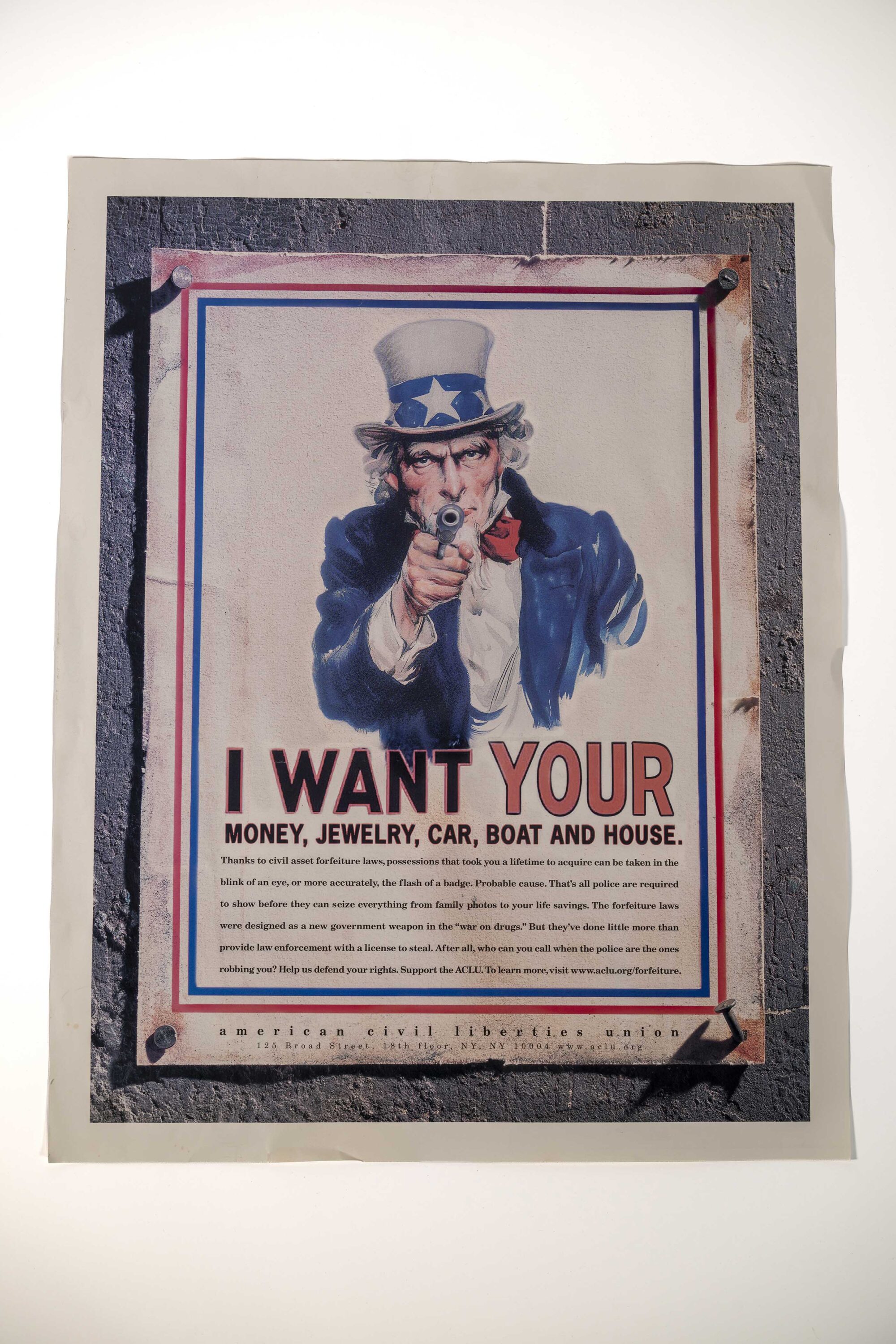 Photo of ACLU Poster featuring Uncle Sam and the text: "I Want Your Money, Jewelry, Car, Boat & House"