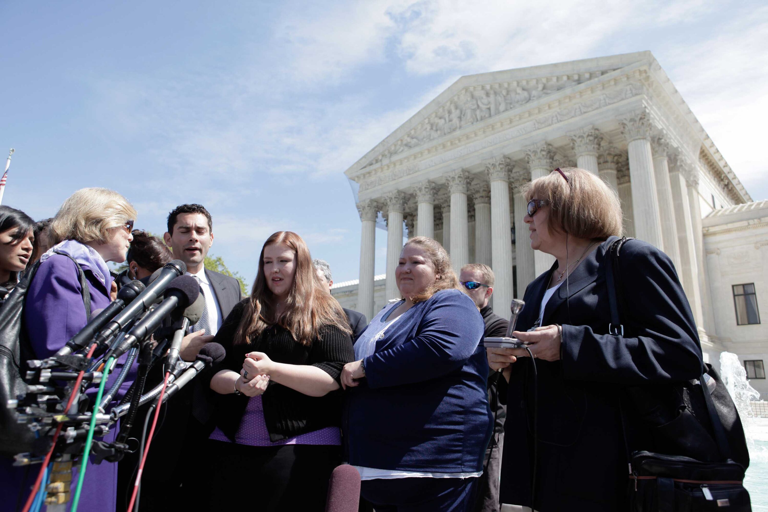 Adam Wolf, Savana Redding and April Redding surrounded by members of the media outside the Supreme Court