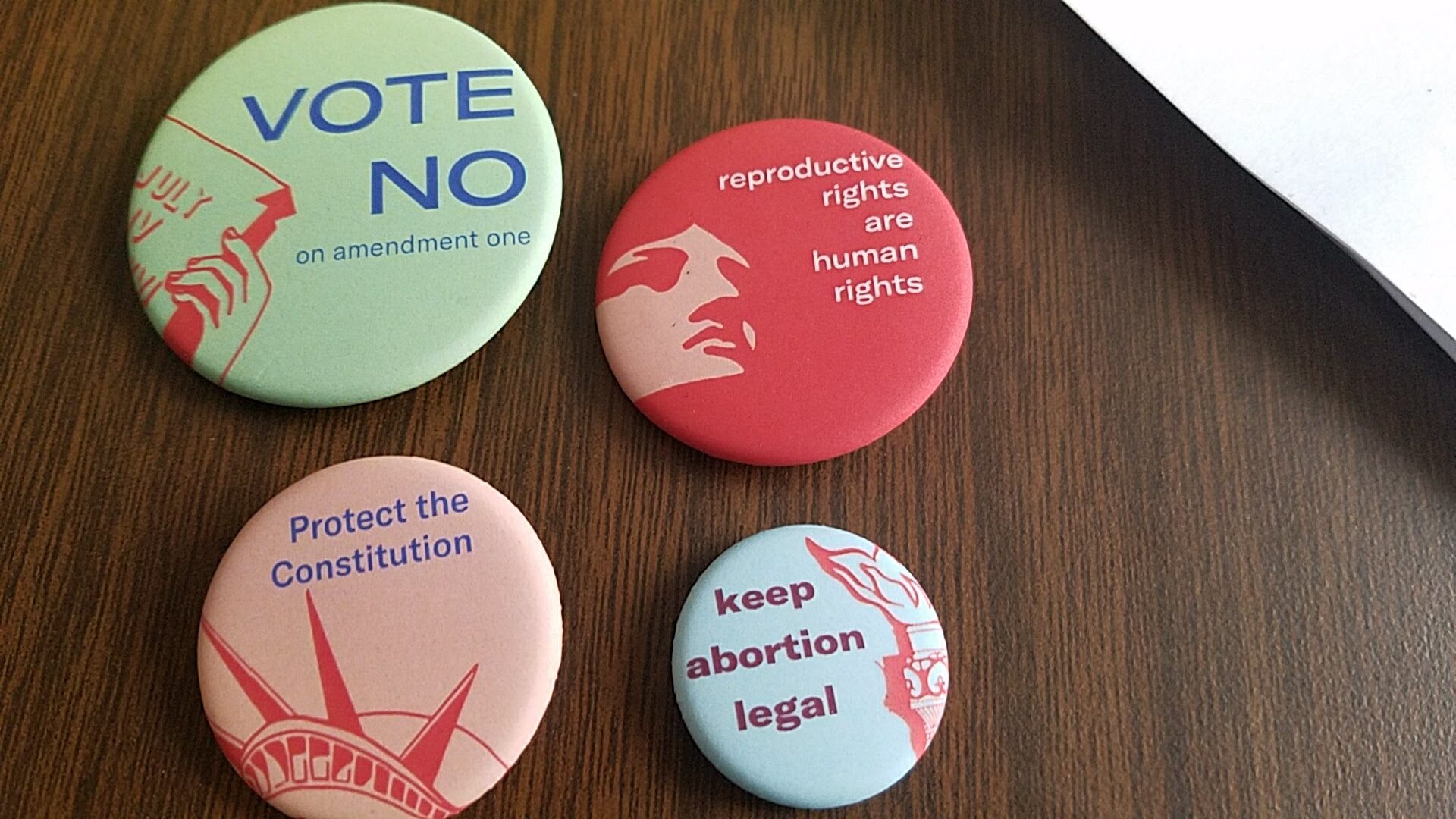 Photo of four colorful ACLU of West Virginia reproductive rights pins