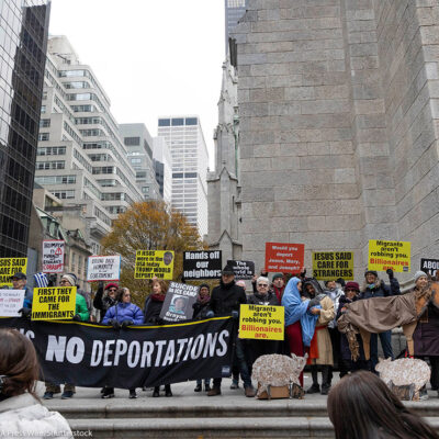 Anti-ICE demonstrators holding signs that say "NO DETENTIONS NO DEPORTATIONS' and 'FIRST THEY CAME FOR THE IMMIGRANTS."