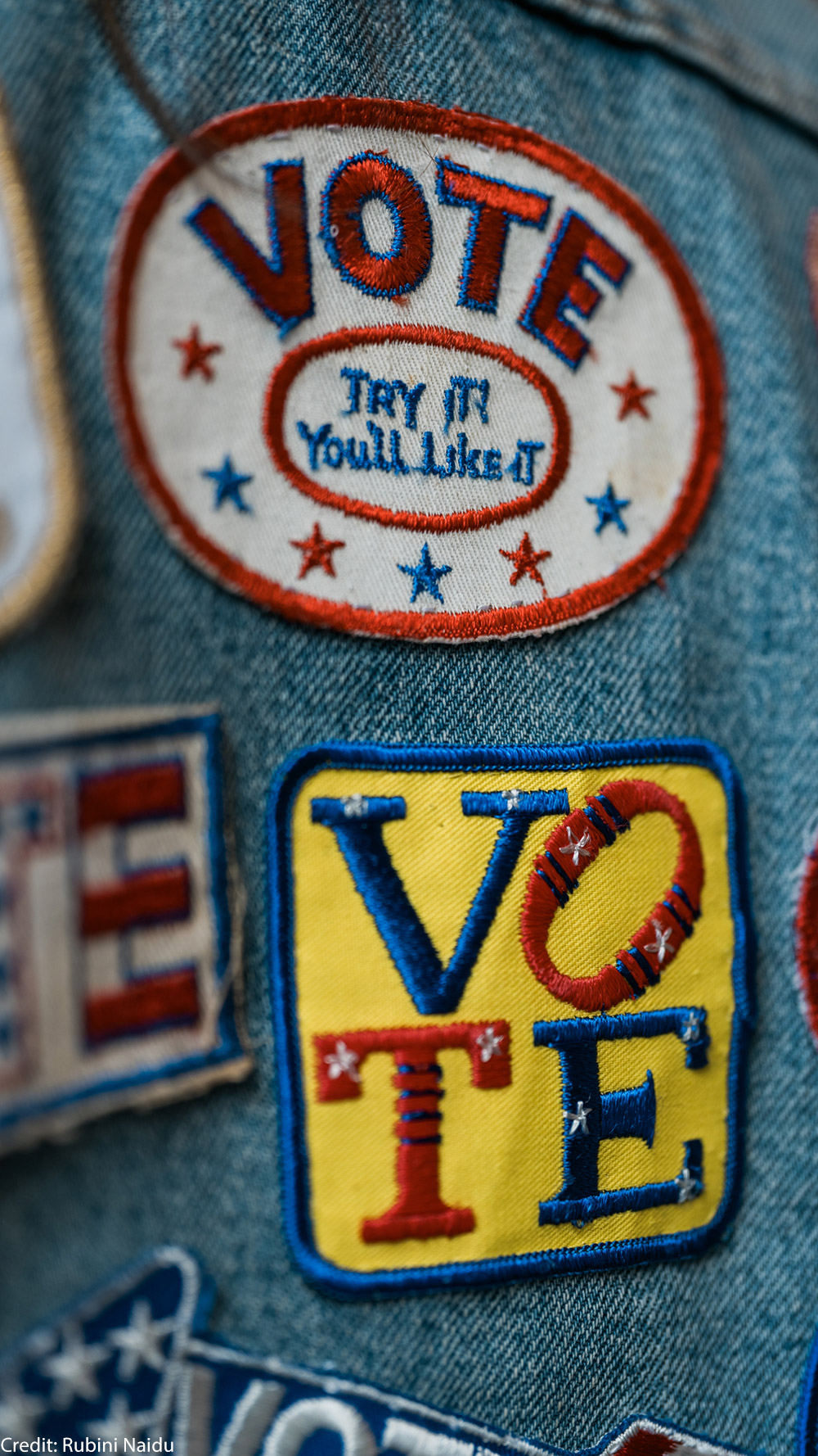 A group of patches on denim encouraging people to vote.