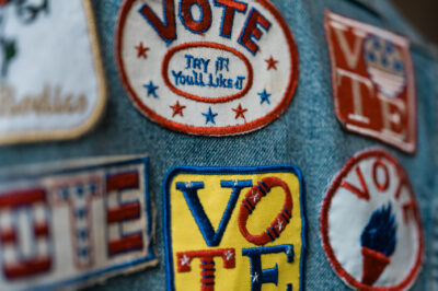 A group of patches on denim encouraging people to vote.
