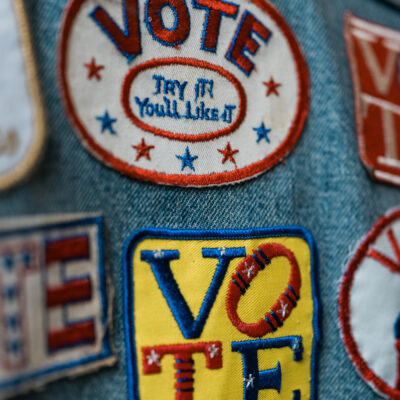 A group of patches on denim encouraging people to vote.
