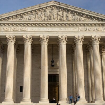 The facade of the Supreme Court of the United States building against a blue sky,