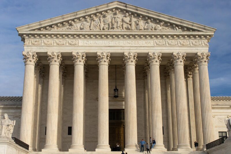 The facade of the Supreme Court of the United States building against a blue sky,